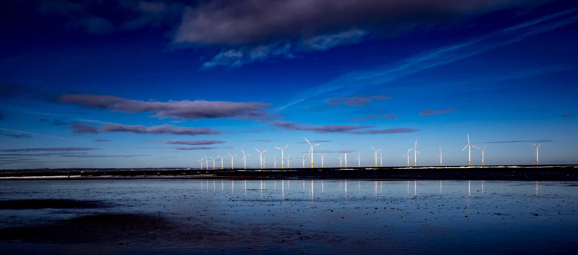 Offshore wind farm at dusk and low tide