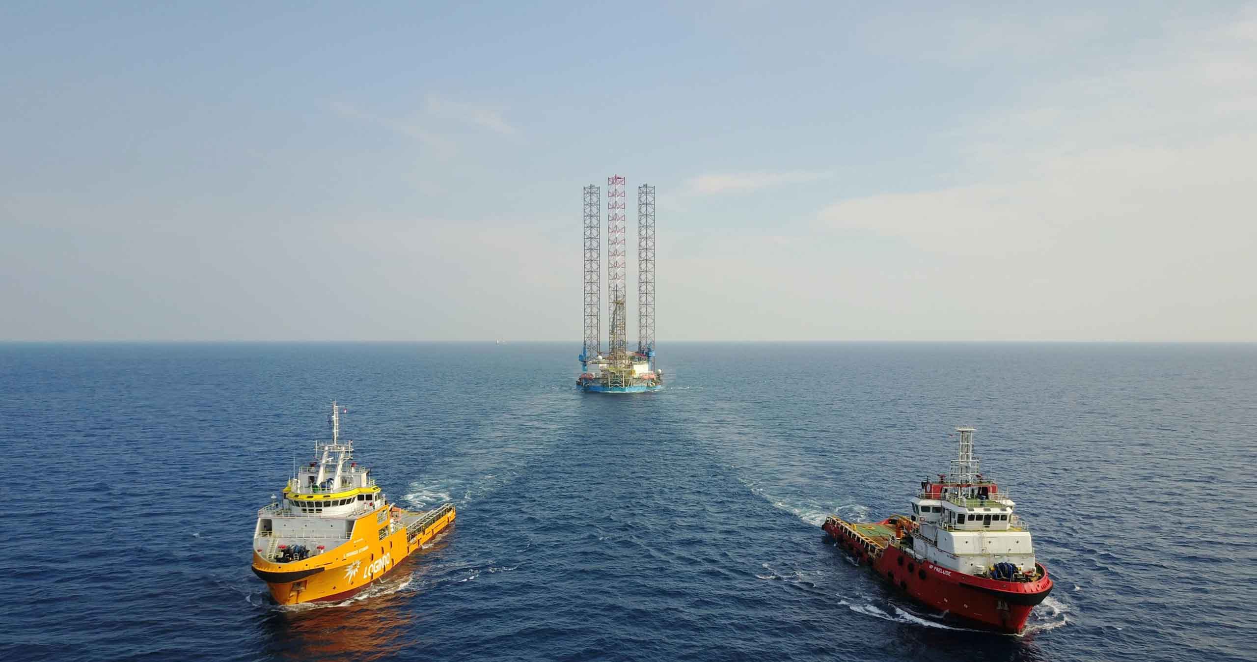Two tugs towing a jack-up rig